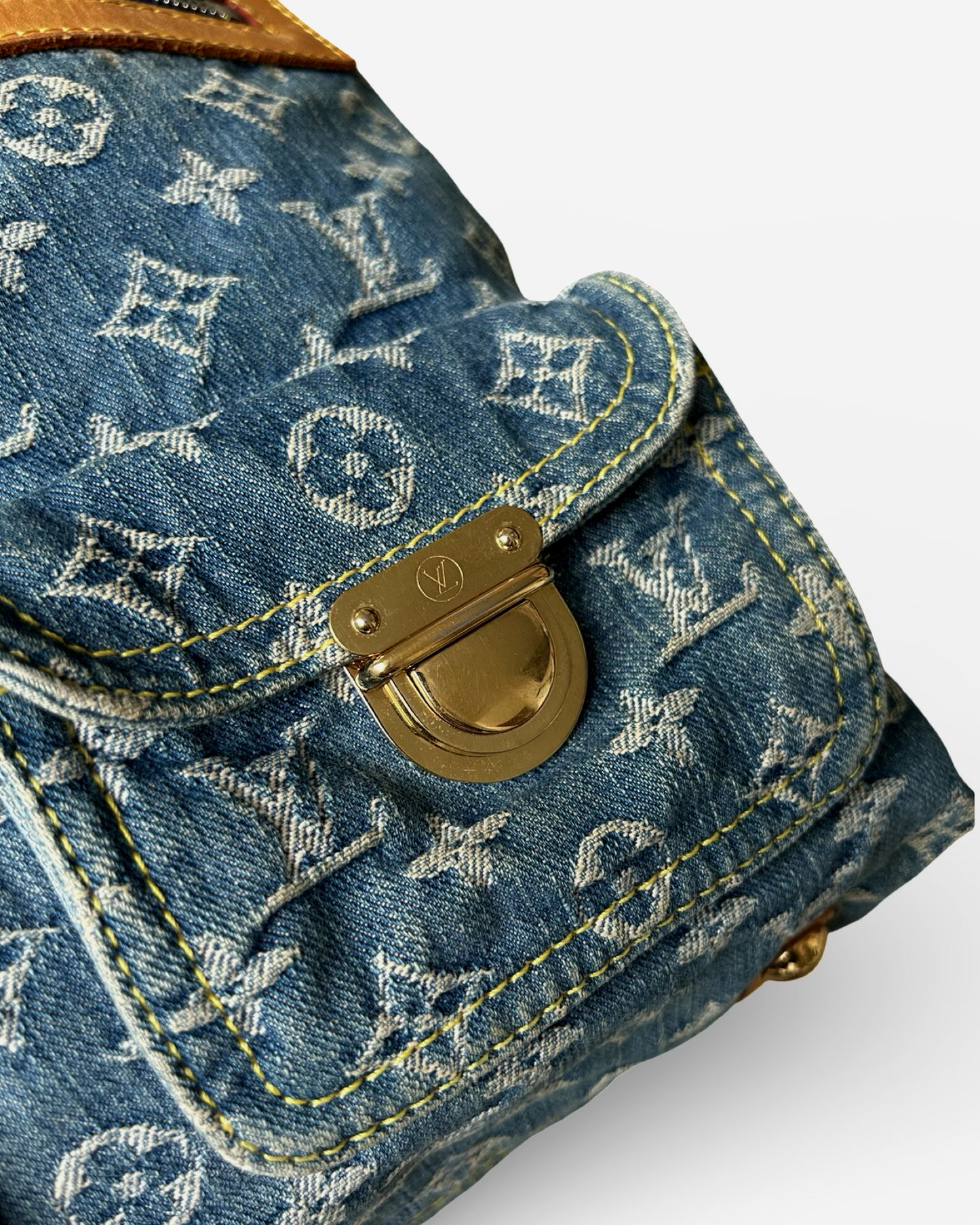 Louis Vuitton Monogram Denim Baggy GM Shoulder Bag close-up showing gold-tone press-lock closure and blue denim.