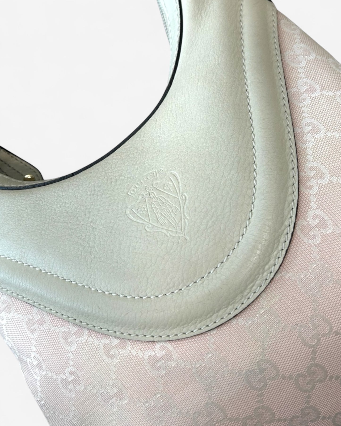 Close-up of Gucci crest emblem on Hysteria Hobo bag in pink and crème canvas