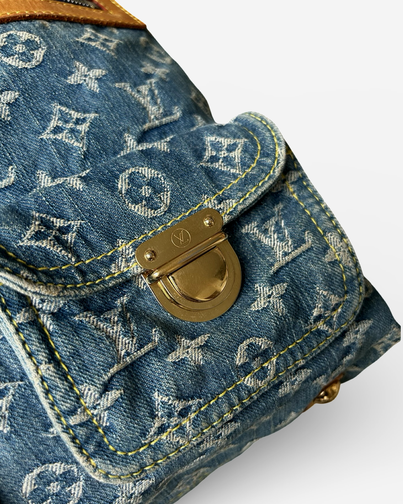 Louis Vuitton Monogram Denim Baggy GM Shoulder Bag close-up showing gold-tone press-lock closure and blue denim.