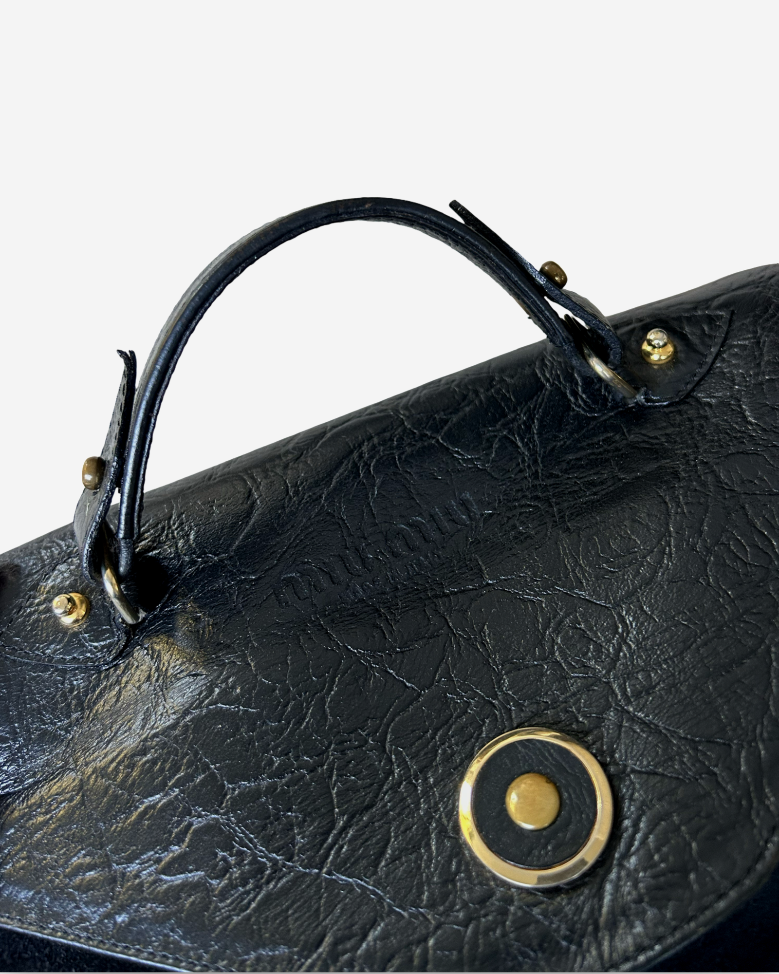 Flap-over closure detail of Miu Miu vintage handbag in black suede and leather