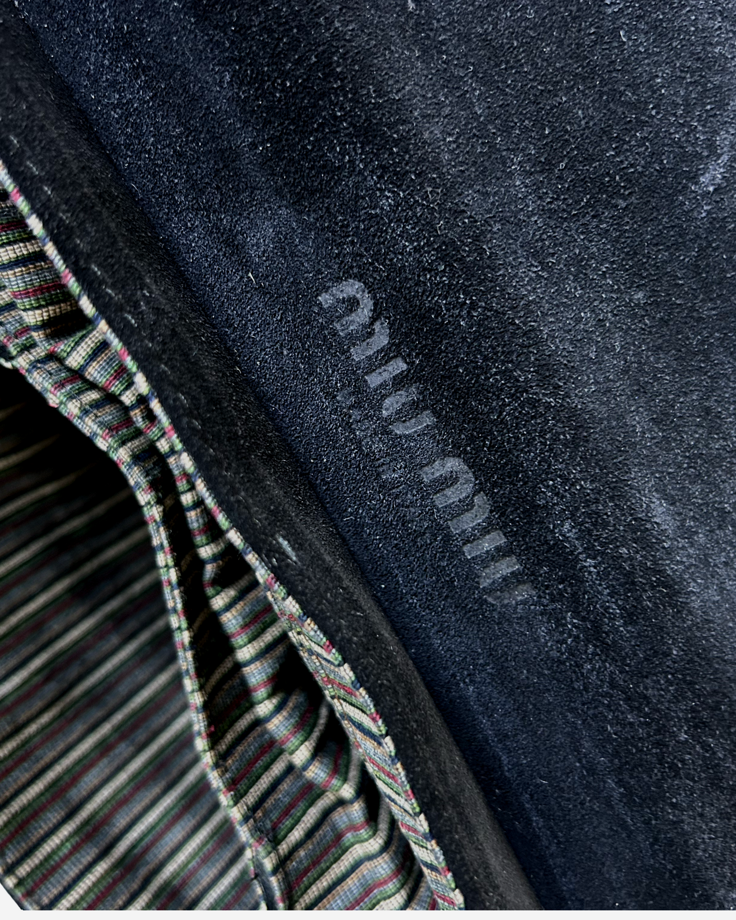 Texture close-up of black suede and smooth leather on vintage Miu Miu handbag