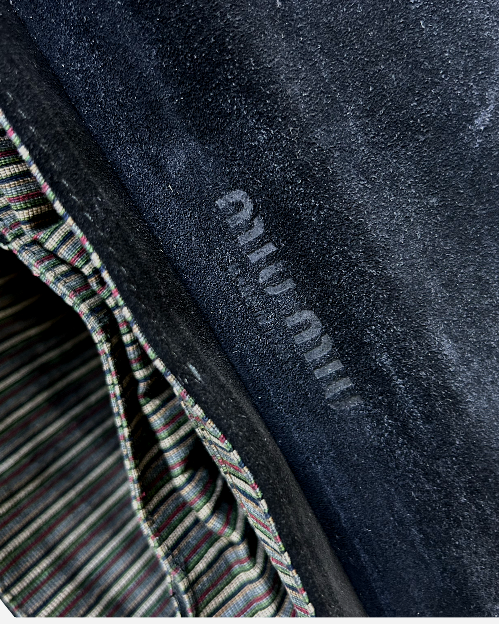 Texture close-up of black suede and smooth leather on vintage Miu Miu handbag