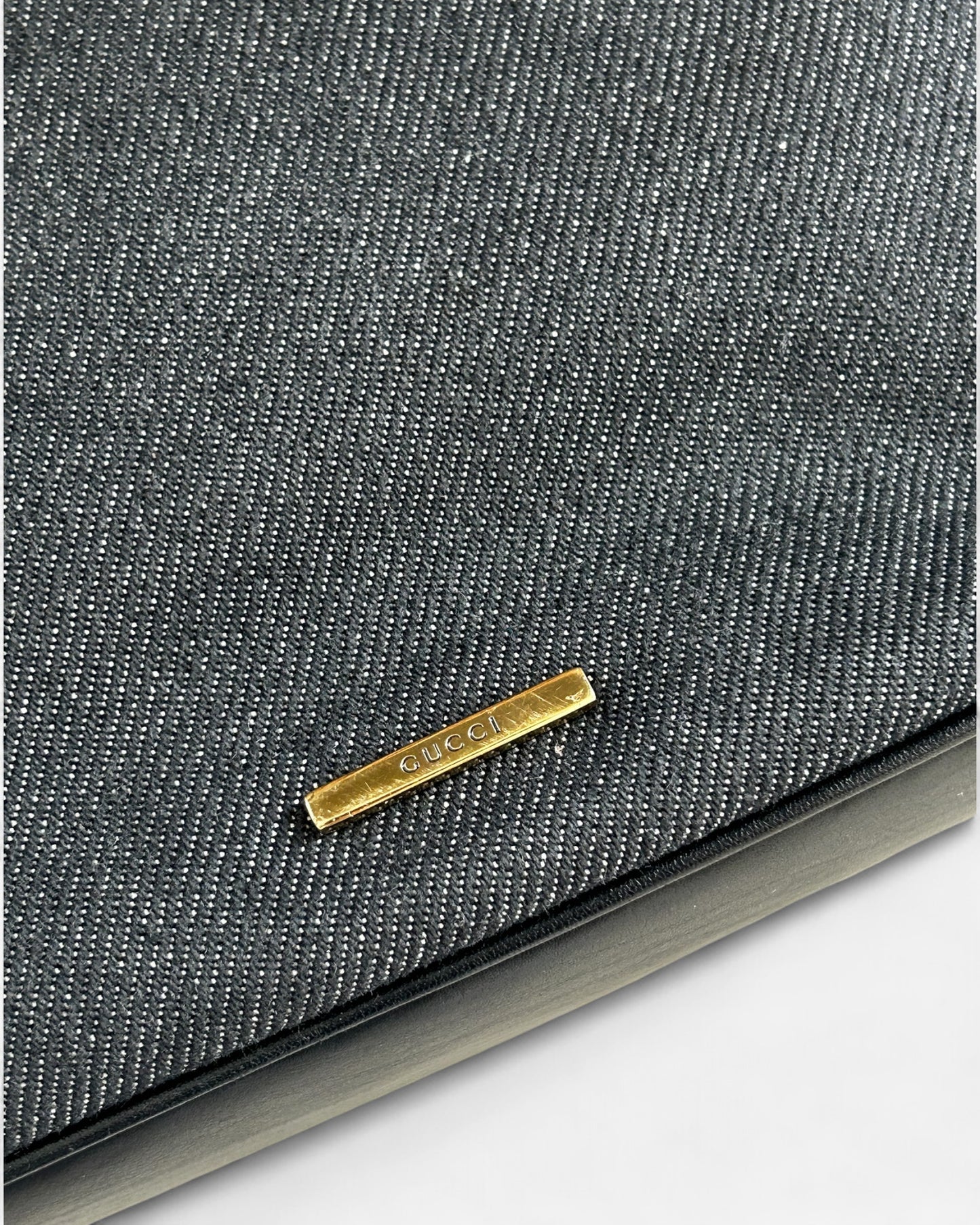 close-up of gucci logo and web detail on denim hobo bag