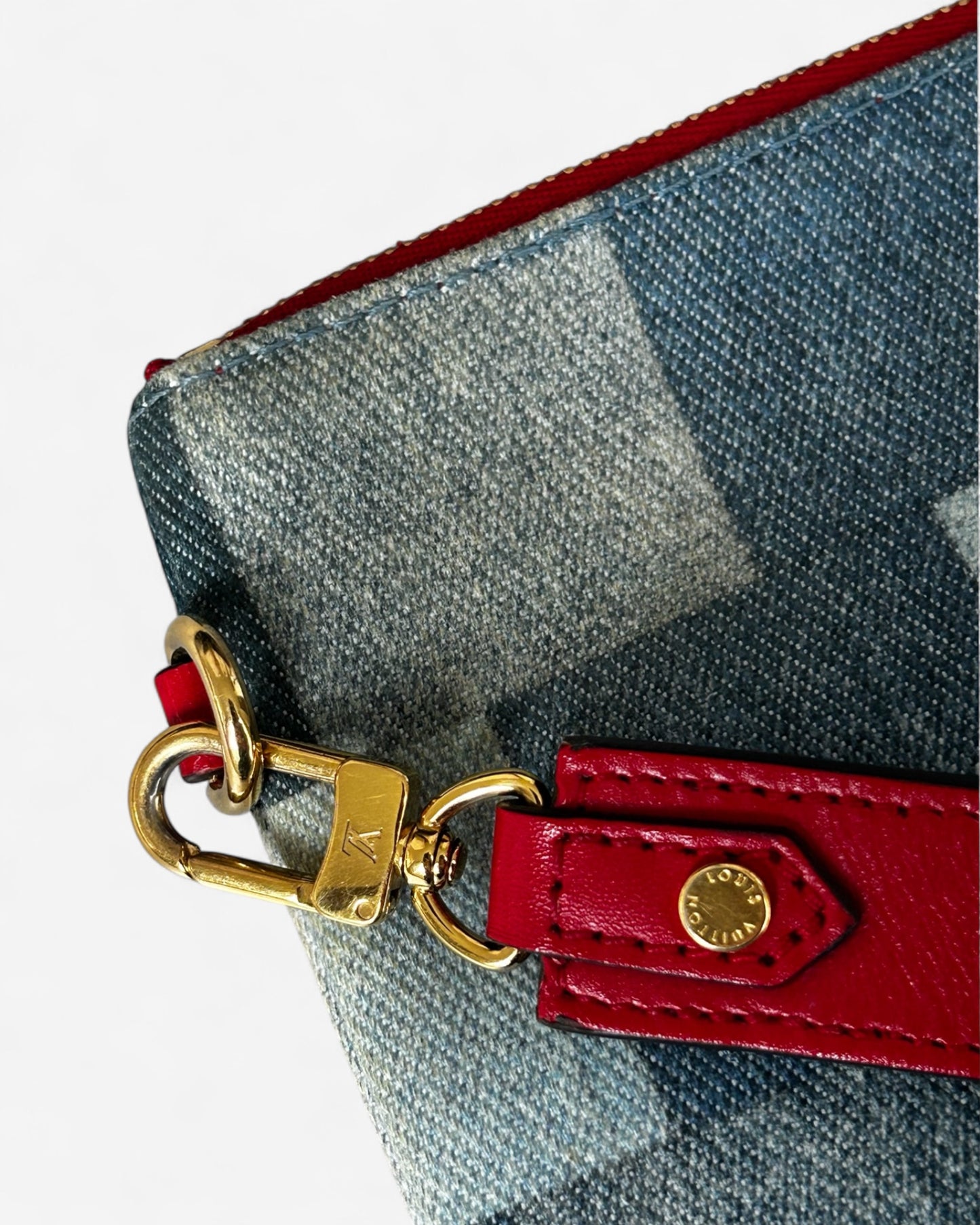 red leather wrist strap detail on lv denim pouch