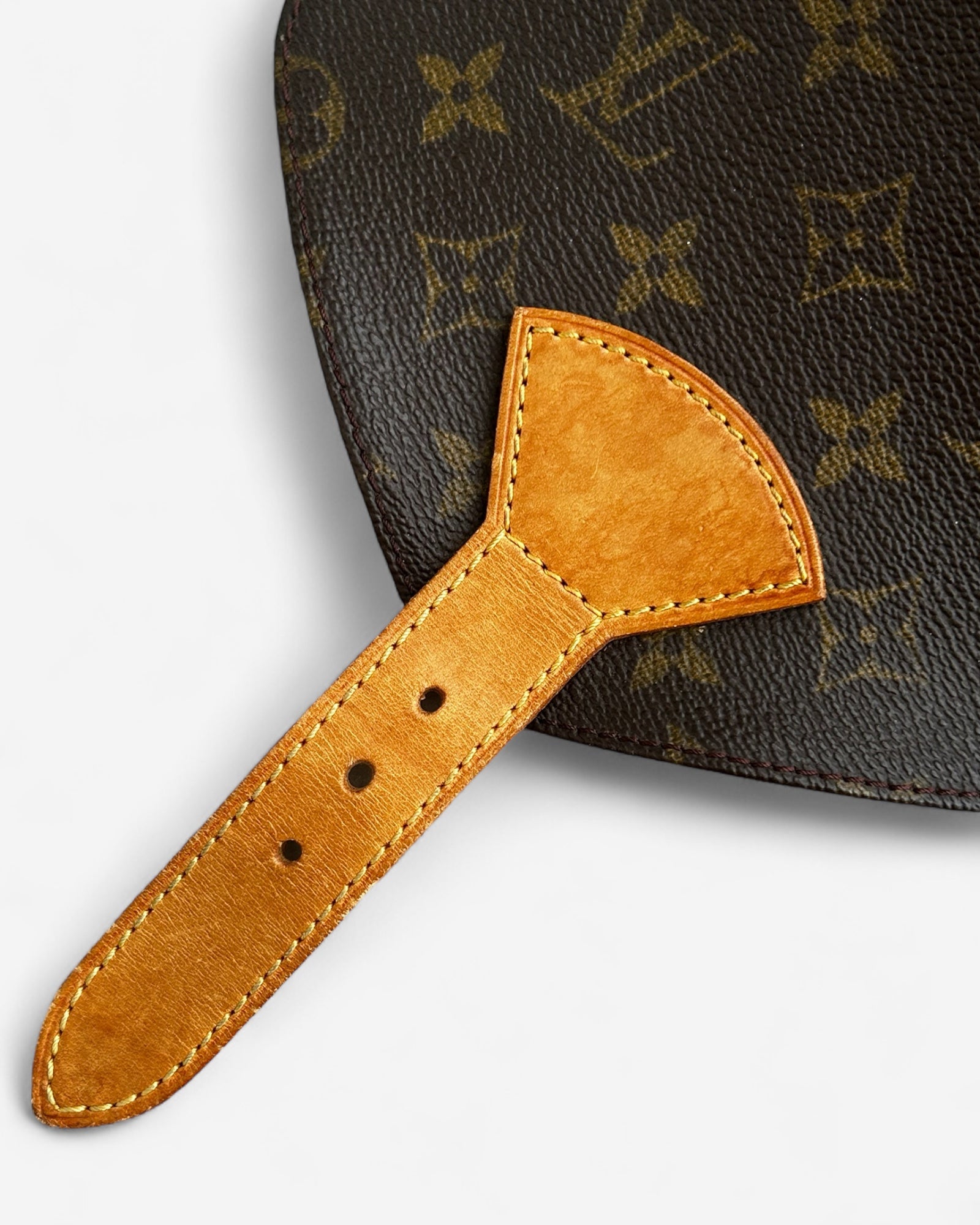 close-up of lv logo on monogram canvas and leather buckle