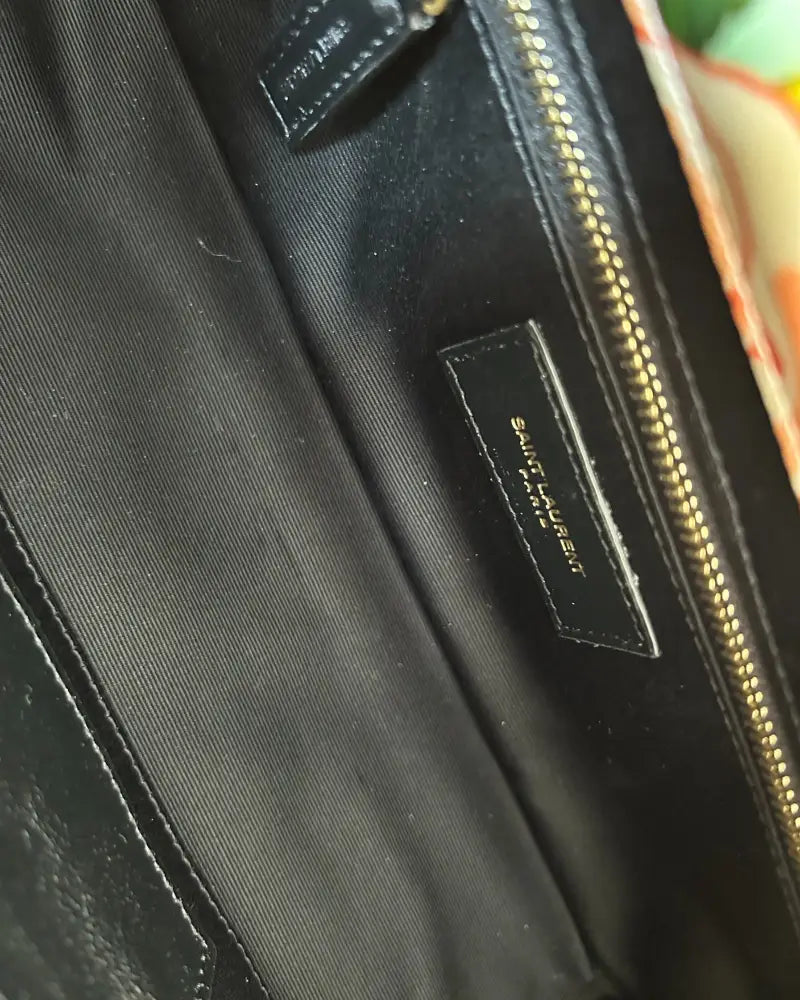 Close-up of YSL logo plaque on Saint Laurent Jamie Medium floral satin bag